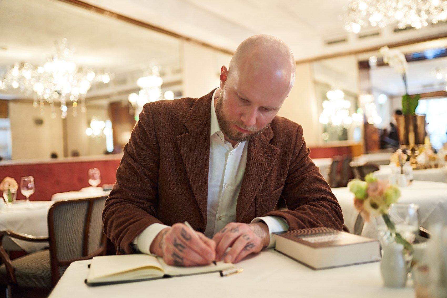 Florian Höper schreibt in ein Notizbuch — Arbeit an Buchinhalten